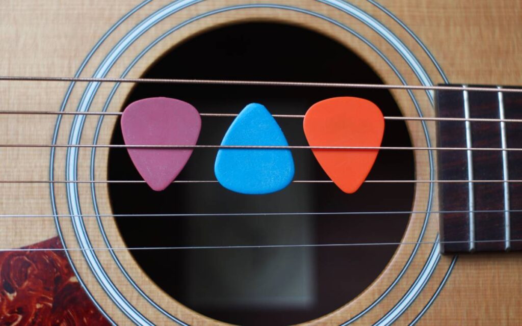 Three colorful guitar picks between strings