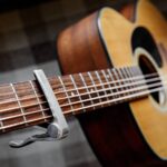 Close-up of acoustic guitar capo on guitar neck