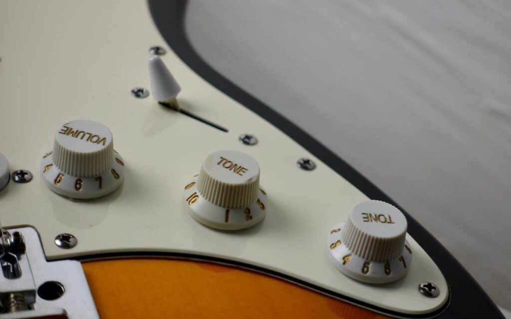 Electric guitar volume and tone knobs close-up