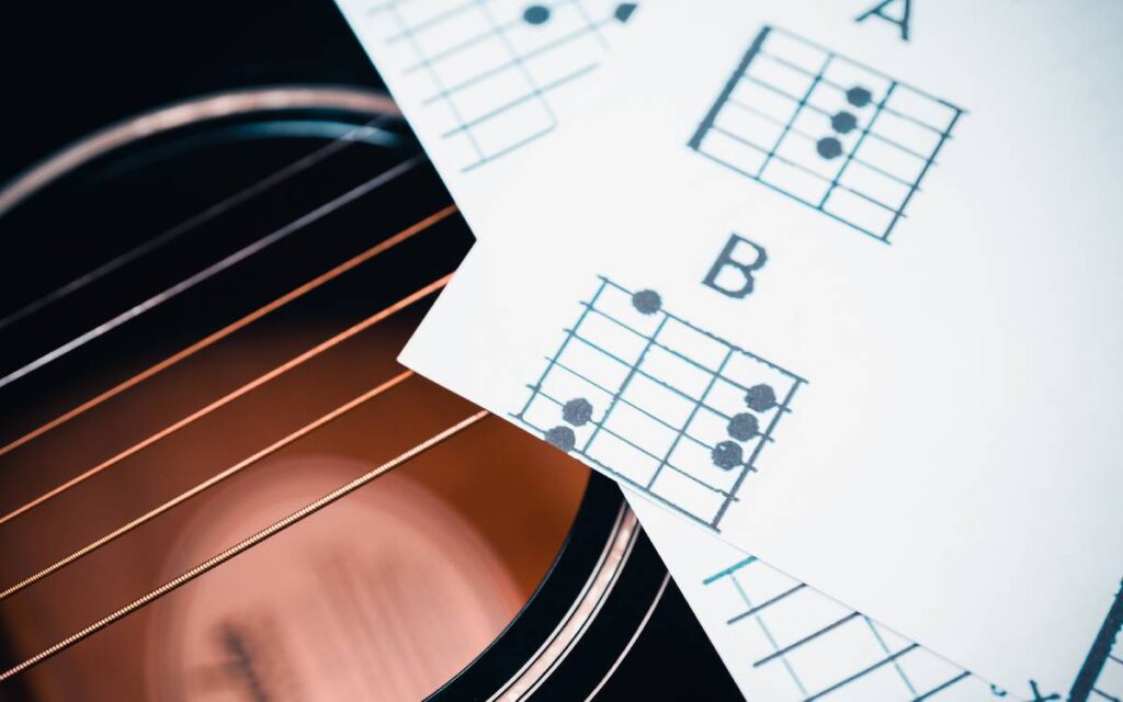Chord charts lying on top of an acoustic guitar