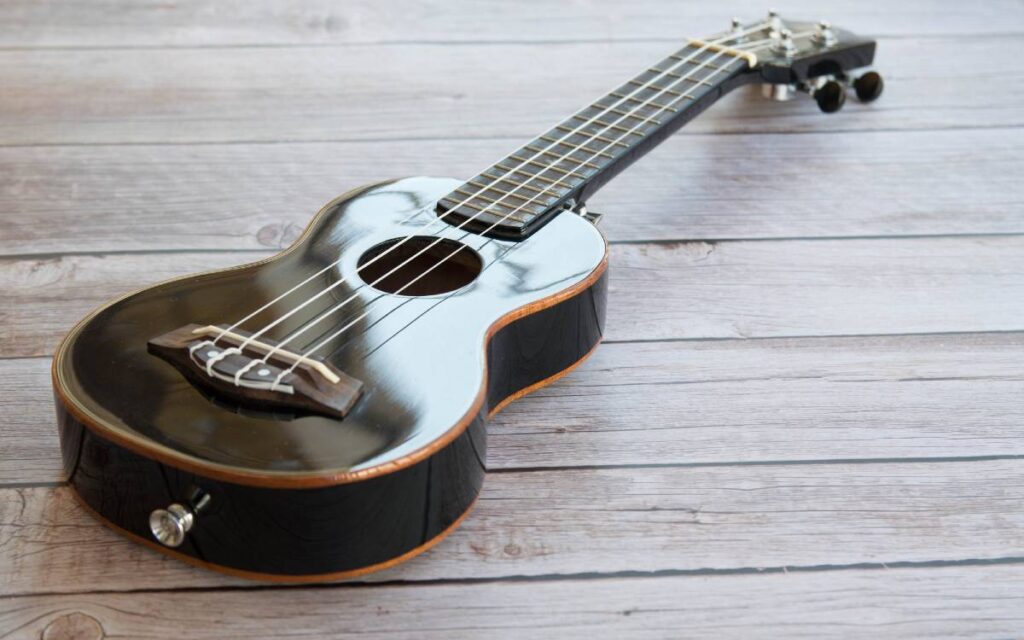 Good inexpensive black ukulele on wooden table