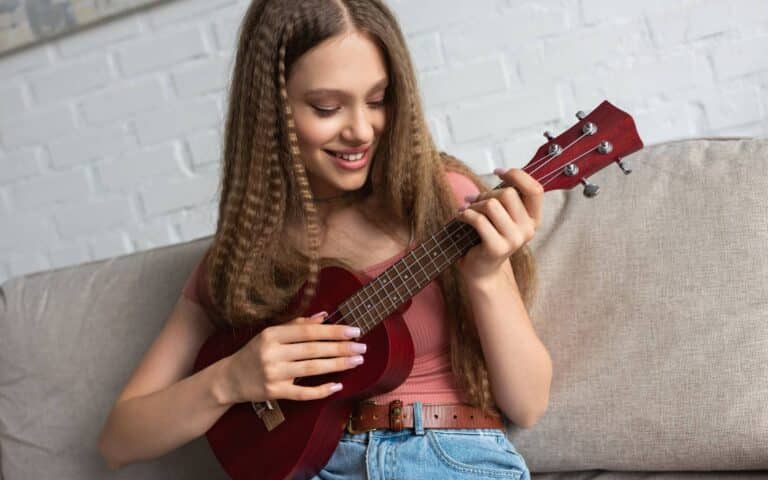 I can't help myself (sugar pie honey bunch) ukulele chords_teenage girl playing ukulele while sitting on a couch in her living room