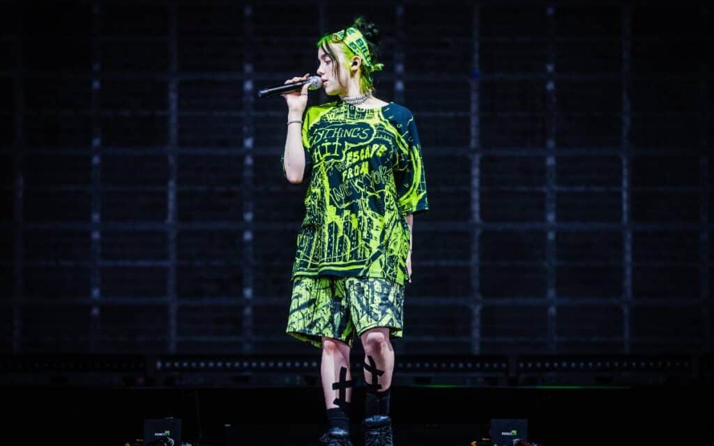 Billie eilish standing on stage while singing